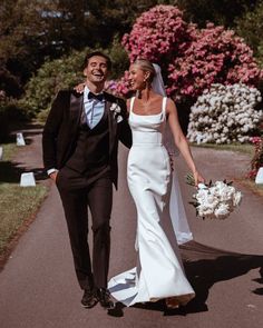 a bride and groom are walking down the street