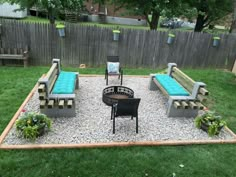 an outdoor seating area with benches and fire pit in the middle, surrounded by grass