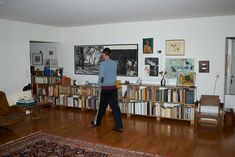 a man standing in front of a book shelf filled with books