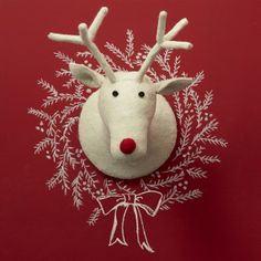 a white reindeer head on top of a red wall