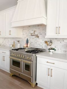 a stove top oven sitting inside of a kitchen next to white cabinets and counter tops