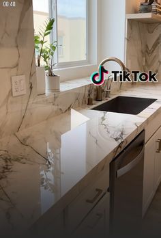 a kitchen with marble counter tops and white cabinets in the background, there is a window that reads tiktok