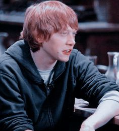 a man with red hair sitting at a table