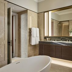 a bathroom with a large bathtub next to a walk in shower and two sinks