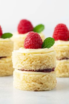 several small cakes with raspberries on top