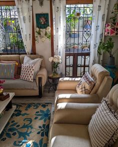 a living room filled with lots of furniture and windows covered in white curtained drapes