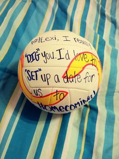 a volleyball with writing on it sitting on top of a blue and white striped blanket