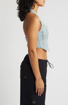 Amp up your edge in this cropped halter top designed in light-wash denim with a zip closure and corset-inspired details. 8 1/2" center front length (size Medium) Front zip closure Halter neck 95% cotton, 4% polyester, 1% spandex Machine wash, line dry Imported Casual Denim Blue Corset, Cropped Denim Corset For Summer, Light Wash Fitted Denim Crop Top, Fitted Light Wash Denim Crop Top, Fitted Light Wash Cropped Top, Spring Cropped Denim Corset, Light Wash Cropped Denim Crop Top, High Waist Denim Crop Top In Medium Wash, Fitted Washed Blue Cropped Denim Top