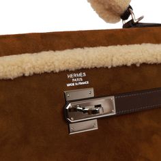 This rare Teddy Kelly bag in the Retourne style is in shearling and Ebene barenia leather with palladium hardware and has tonal stitching, a front toggle closure, a clochette with lock and two keys, a single rolled handle and an optional shoulder strap.The interior is lined in Ebene chevre and features one zip pocket with an Hermes engraved pull and two open pockets on opposite side. Collection: L squareOrigin: FranceCondition: Pre-owned ; Excellent to Mint - This bag retains its structure. The Luxury Sheepskin Bags With Faux Fur Lining, Holiday Handbag, Hermes Box, Kelly Bag, Sneaker Jewelry, Hermes Handbags, Burberry Shoes, Handbags On Sale, Leather Handbags