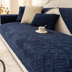 a bed with blue bedspread and white pillows