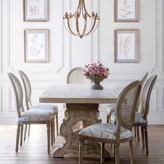 a dining room table with four chairs and a chandelier hanging from the ceiling