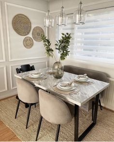 a dining room table with chairs and plates on it