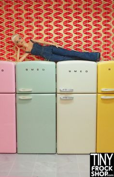 a person laying on top of four refrigerators