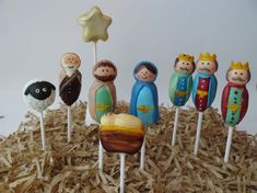 there are many small cake toppers on the sticks in the hay pile, and one is holding a star