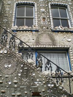 an old building with decorative decorations on the side and windows in front, along with a staircase leading up to it