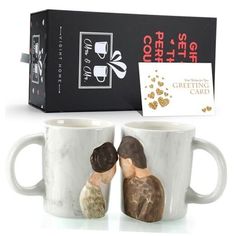 two coffee mugs with the same design on them and a gift card in front