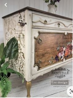 an old dresser painted white with flowers on it