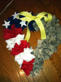 an american flag heart made out of paper and ribbon on top of a wooden floor