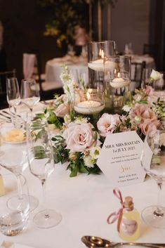 the table is set with wine glasses, candles and floral centerpieces for an elegant wedding reception