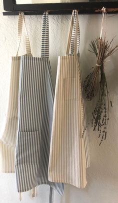 three striped aprons hanging on a wall