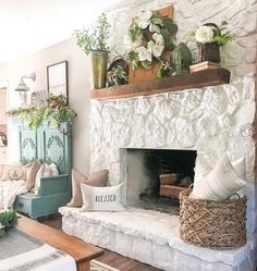 a living room filled with furniture and a fire place covered in plants on top of a mantle