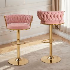 two pink velvet bar stools with gold metal bases in a living room setting, one is facing the other