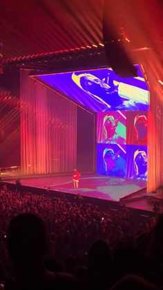 a person standing on top of a stage in front of a crowd