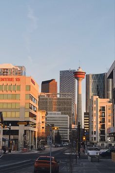 a city street with tall buildings in the background