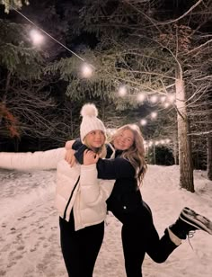 two people standing in the snow posing for a photo with their arms around each other