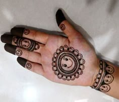 a woman's hand with henna tattoos on it