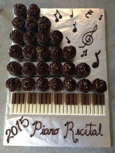 a sheet cake with chocolate icing and music notes on it that says, piano cake made from cupcakes and kit - kits so you can play