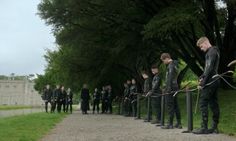 a group of people standing next to each other in front of a tree filled park