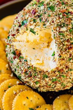 a cheese ball is sitting on top of some crackers and sprinkles