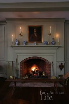 a living room with a fire place and painting on the wall above it's mantle