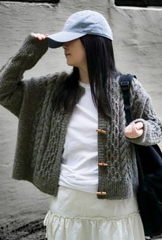 a young woman wearing a hat and sweater