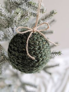 a green ornament hanging from a christmas tree