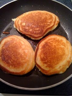 three pancakes cooking in a pan on the stove