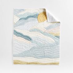 a quilted blanket with waves and sun in the sky on it's side