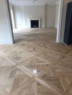 an empty room with wood flooring and white walls in the corner is seen from the doorway