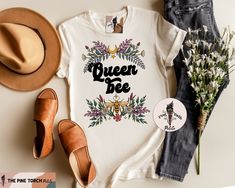 QUEEN BEE (UNISEX TEE) - ▲Designed and handmade in Phoenix.▲ ▲The "PETITE" kids/baby sister shop of THE PINE TORCH® - our main shop with over 100,000 sales and 25,000 5 star reviews - since 2015! ▲ https://www.etsy.com/shop/ThePineTorch 🌈Swoon...this adorable, earthy, gorgeous hand-drawn queen bee is all the buzz. Matches perfectly with our Big Sister Bee and Big Brother Bee (and Little Bee on the Way) designs to make the perfect matching announcement set. * * * * * * * * * * * * * * * * * * * Bee Pregnancy Announcement, Floral Color Palette, Floral Tees, Moody Boho, Bee Family, Mommy And Me Shirts, Big Sister Little Sister, Mommy And Me Shirt, Floral Tee