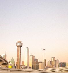 a man riding a skateboard on top of a cement ramp in front of a city skyline