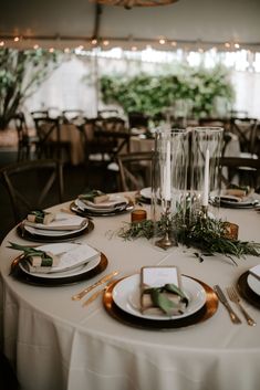 the table is set with plates and place settings for an elegant dinner or reception party