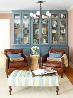 a living room with two chairs and a ottoman