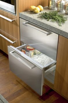 an open dishwasher in a kitchen next to a counter