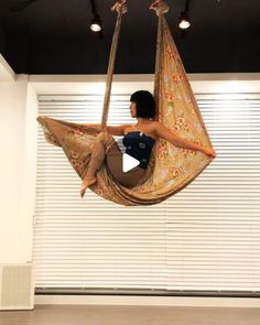 a woman is sitting in a hammock chair