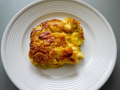 a white plate topped with an omelet on top of a gray countertop