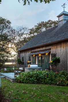 a small wooden building sitting on top of a lush green field