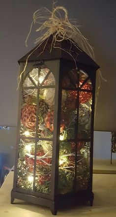 a lantern with lights in it sitting on top of a table