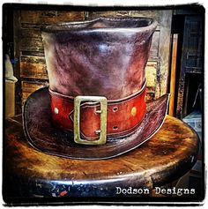 You can't get more stylish than a hand-crafted leather top hat! These hats are made entirely by hand. And can be customized to suit your costume or look. Whether you want to go with a badass biker look, a steampunk, or another genre, this leather hat adds a ton of character to your costume or look. I make these out of genuine full-grain vegetable-tanned leather. Each hat is hand-dyed and then stitched by hand to your needs.  A simple hat bad is included in the price, but a more creative and fanc Steampunk Leather Top Hat With Flat Crown, Handmade Vintage High Crown Top Hat, Vintage Top Hat For Western-themed Events, Fitted Leather Top Hat With High Crown, Vintage Fitted Hat For Cosplay, Fitted Vintage Hat For Cosplay, Custom Handmade Brown Top Hat, Leather High Crown Top Hat For Festival, Custom High Crown Leather Hat