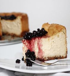 a piece of cheesecake on a plate with a fork next to it and another slice missing